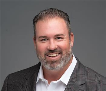 Man with salt and pepper beard wearing brown sport coat